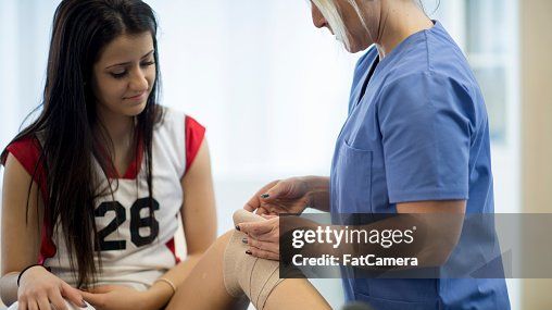 athletic trainer assessing a knee